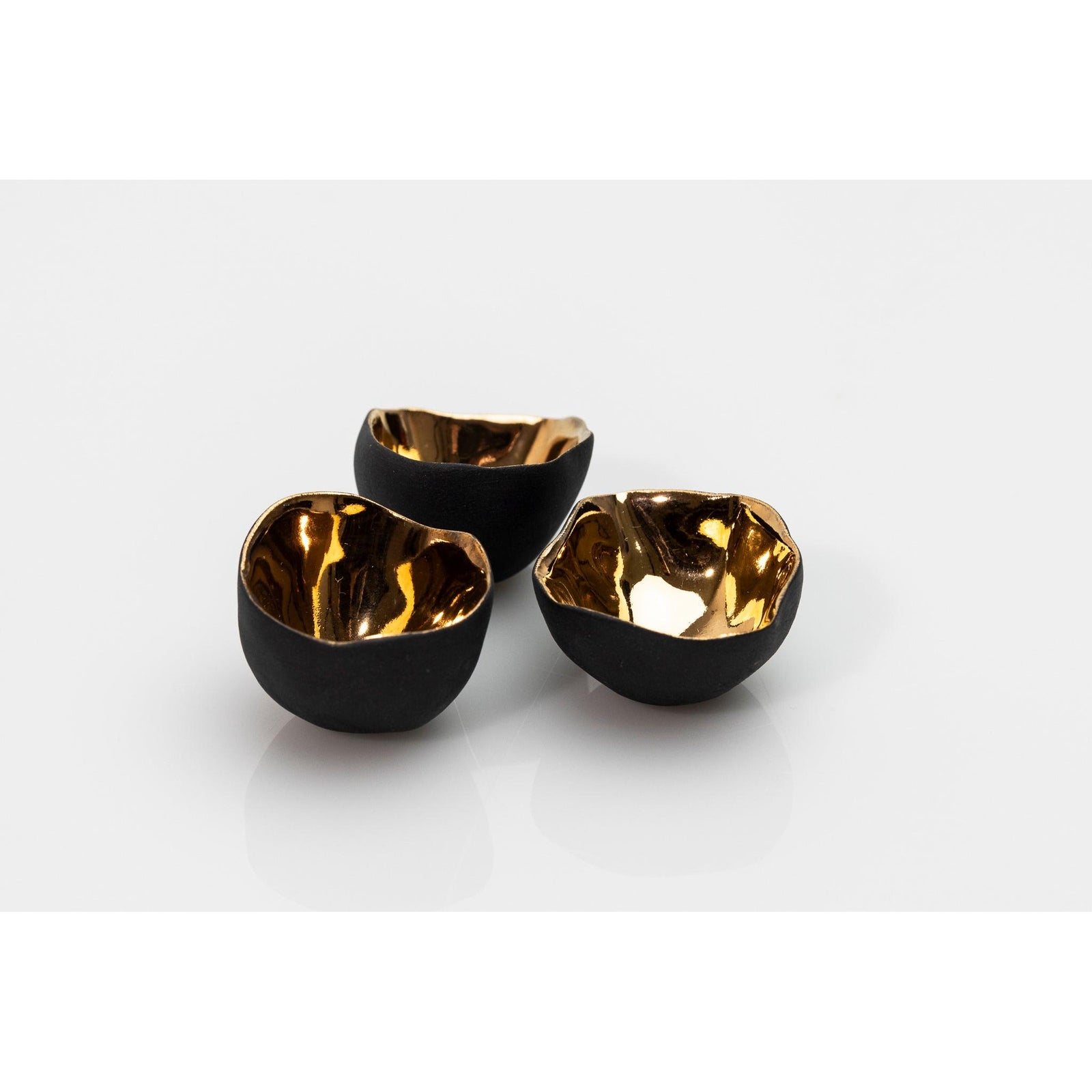 PL04 Trio of Bowls, black porcelain and gold lustre by Penny Little. Available at Padstow Gallery, Cornwall