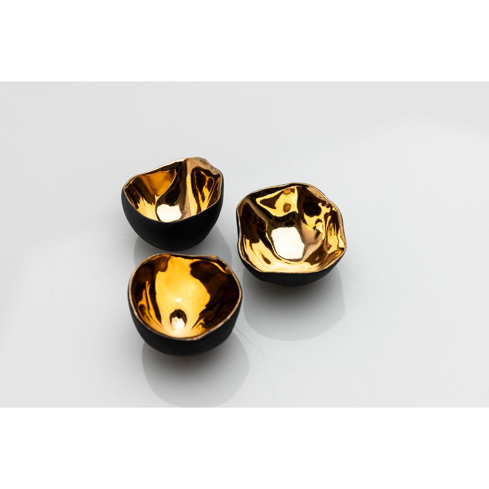 PL04 Trio of Bowls, black porcelain and gold lustre by Penny Little. Available at Padstow Gallery, Cornwall