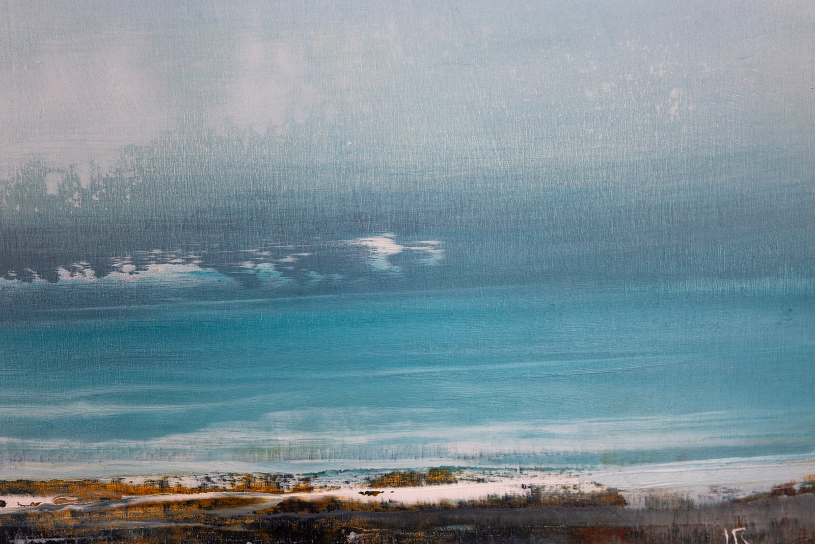 Framed artwork of a landscape with a blue sky and water.